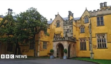 Ashton Court Mansion. It is a yellow, grand-looking building made of stone.