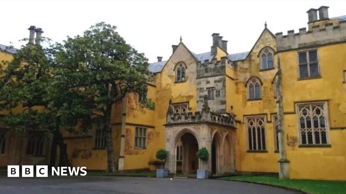 Ashton Court Mansion. It is a yellow, grand-looking building made of stone.