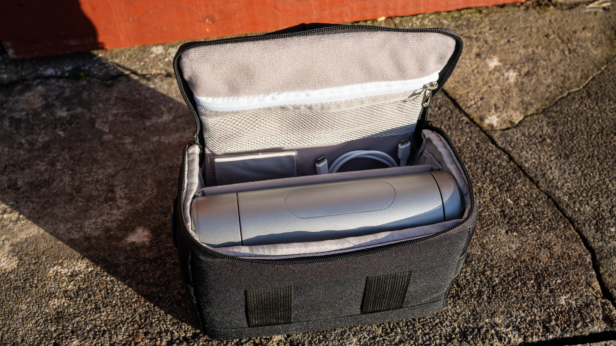 The DWARF 3 in the carry case, placed on a stone wall.