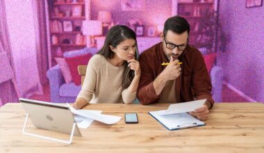 Young couple looking at bills sitting at kitchen table
