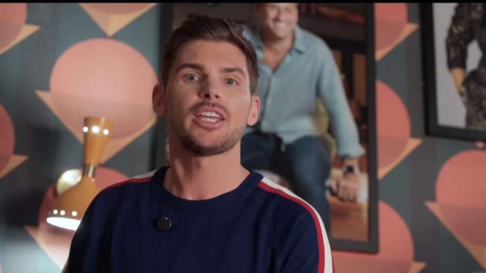 hollyoaks, kieron richardson in front of a portrait of tony hutchinson