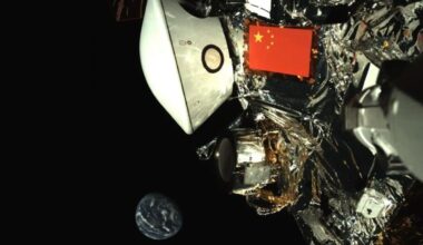 A Chinese flag flies on a metal spacecraft with the Earth in the background in the darkness of space