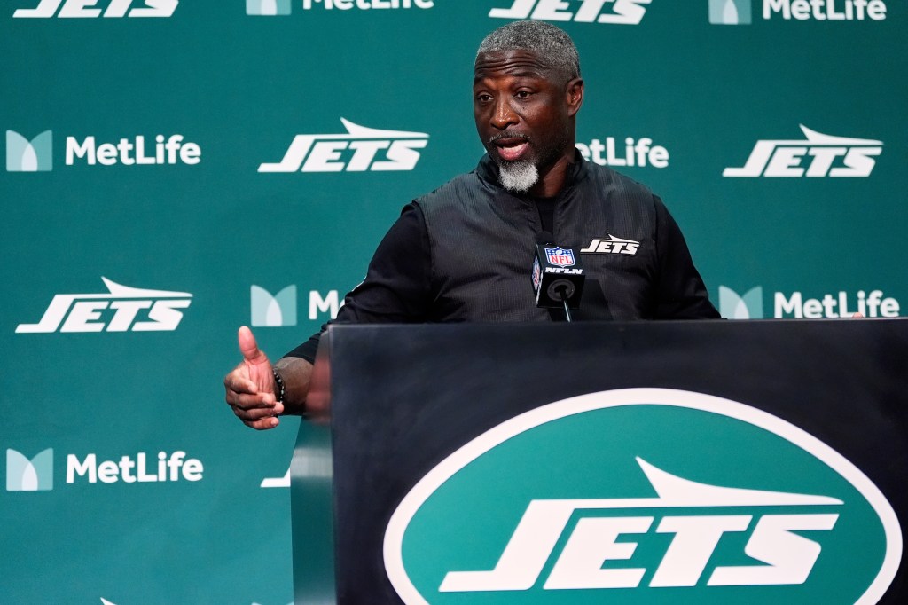 New York Jets head coach Aaron Glenn speaks at a podium.