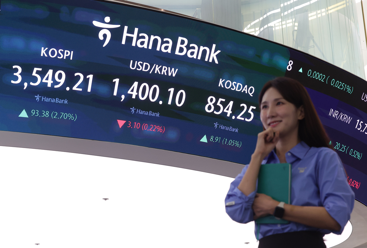 Dealers work at Hana Bank’s dealing room in central Seoul on Oct. 2, as the benchmark Kospi closes at a record high of 3,549.21, surpassing the 3,500 mark for the first time. (Yonhap)