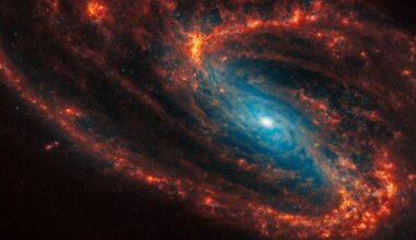 A photo of a spiral galaxy with orange arms and a glowing blue center