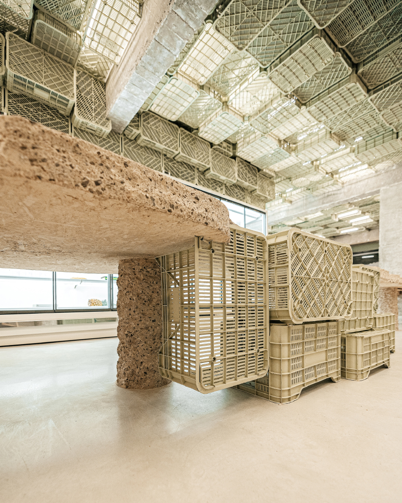 ceiling of recycled plastic crates expands over brutalist supermarket in mallorca