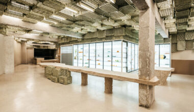 ceiling of recycled plastic crates expands over brutalist supermarket in mallorca