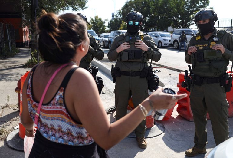 A woman speaks to law enforcement officers during a standoff with U.S. Immigration and Customs Enforcement (ICE) and federal officers in the Little Village neighborhood of Chicago, Illinois, U.S., October 4, 2025. REUTERS/Jim Vondruska