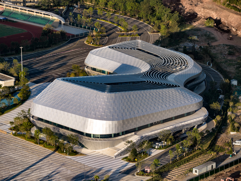 scale-like facade wraps hushan swimming center's undulating form by LYCS architecture