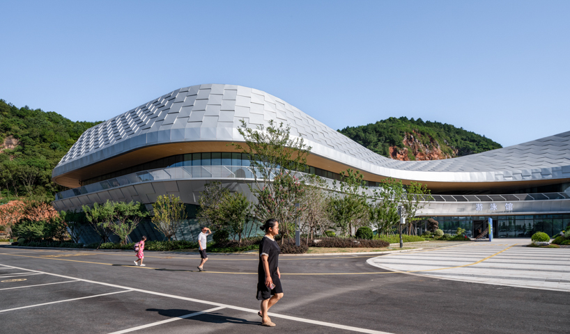 scale-like facade wraps hushan swimming center's undulating form by LYCS architecture