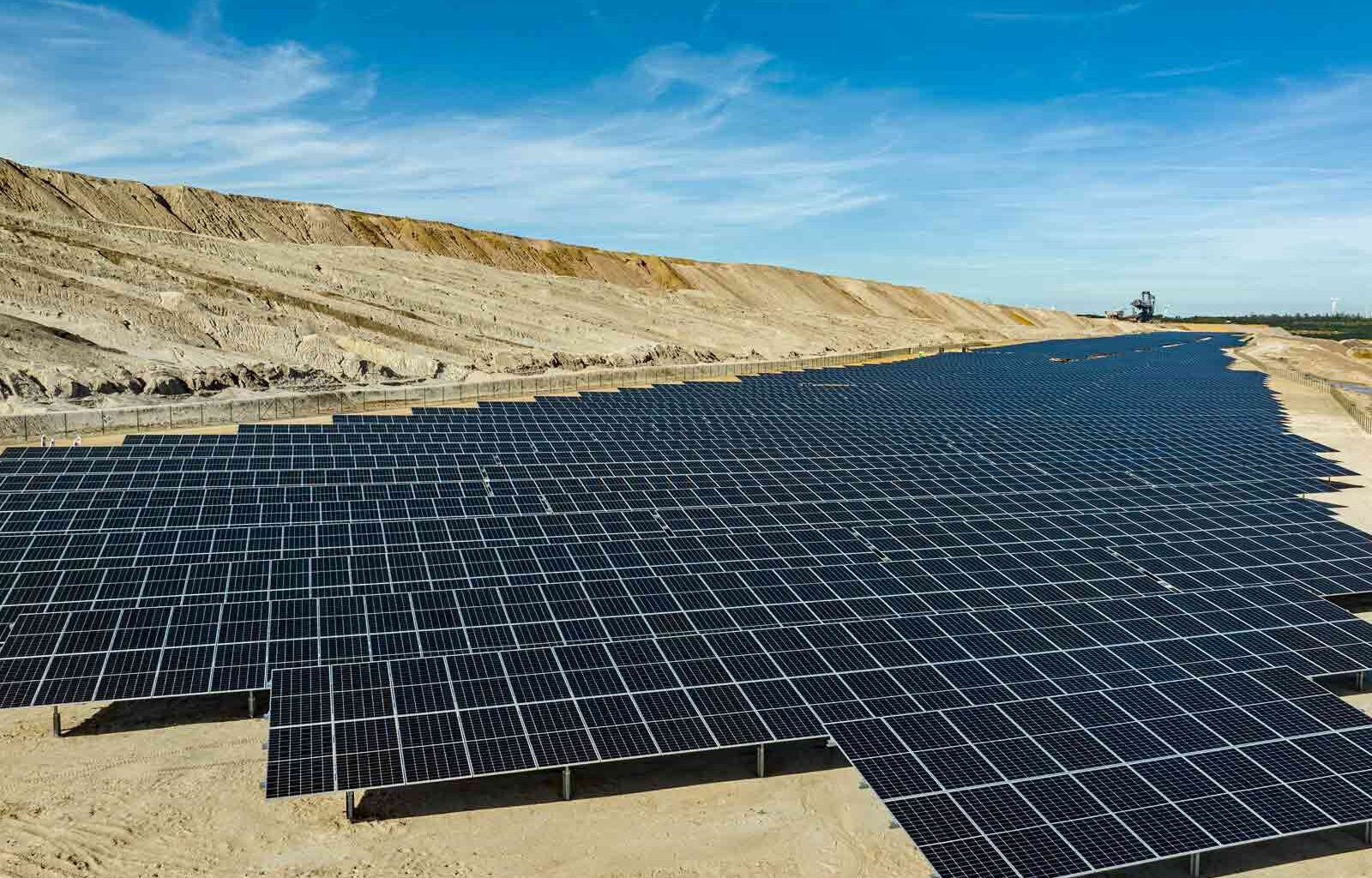 Rows of solar PV modules extend into the background at a former open-cast mine site in Hambach, Germany.