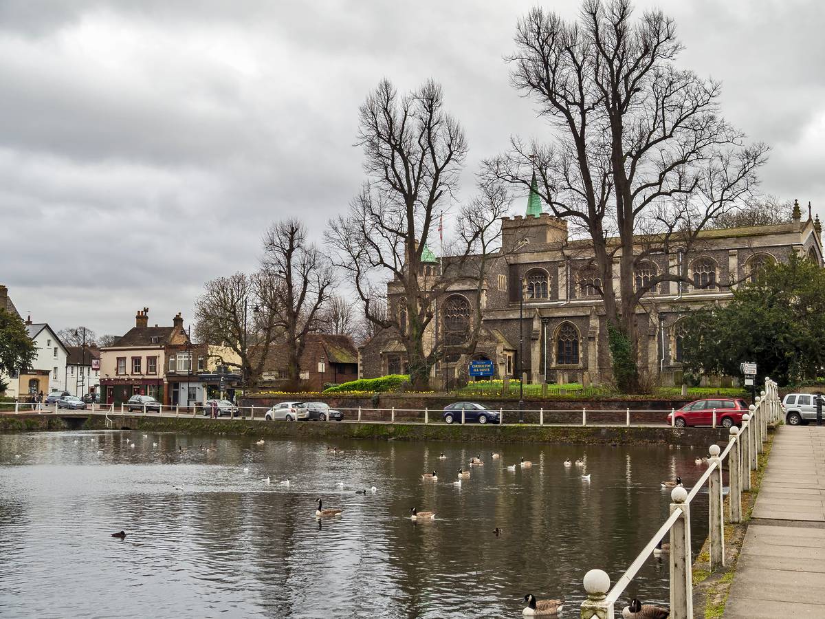 CARSHALTON, ENGLAND - MARCH 15 2020: View to church and high street across Carshalton ponds. Historic village.