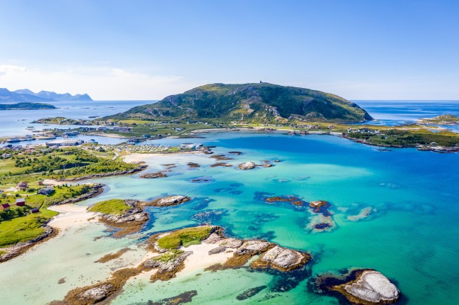 A sunny view over the islets in Sommarøy, northern Norway, surrounded by turquoise blue sea.