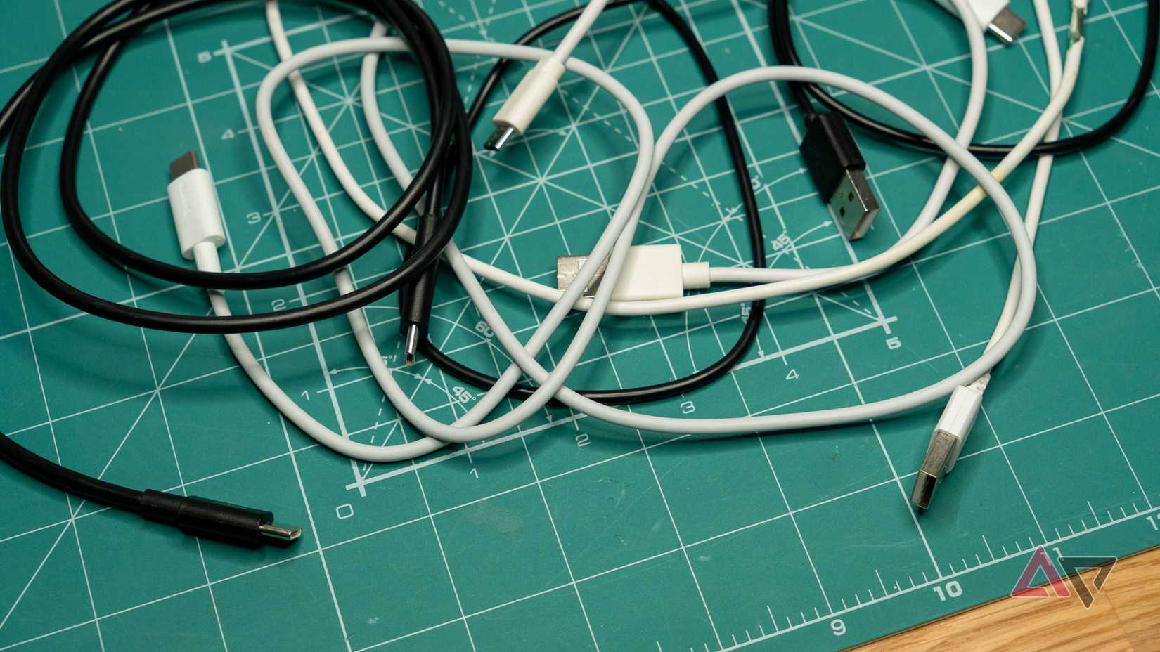 black and white USB cables scattered on a green mat
