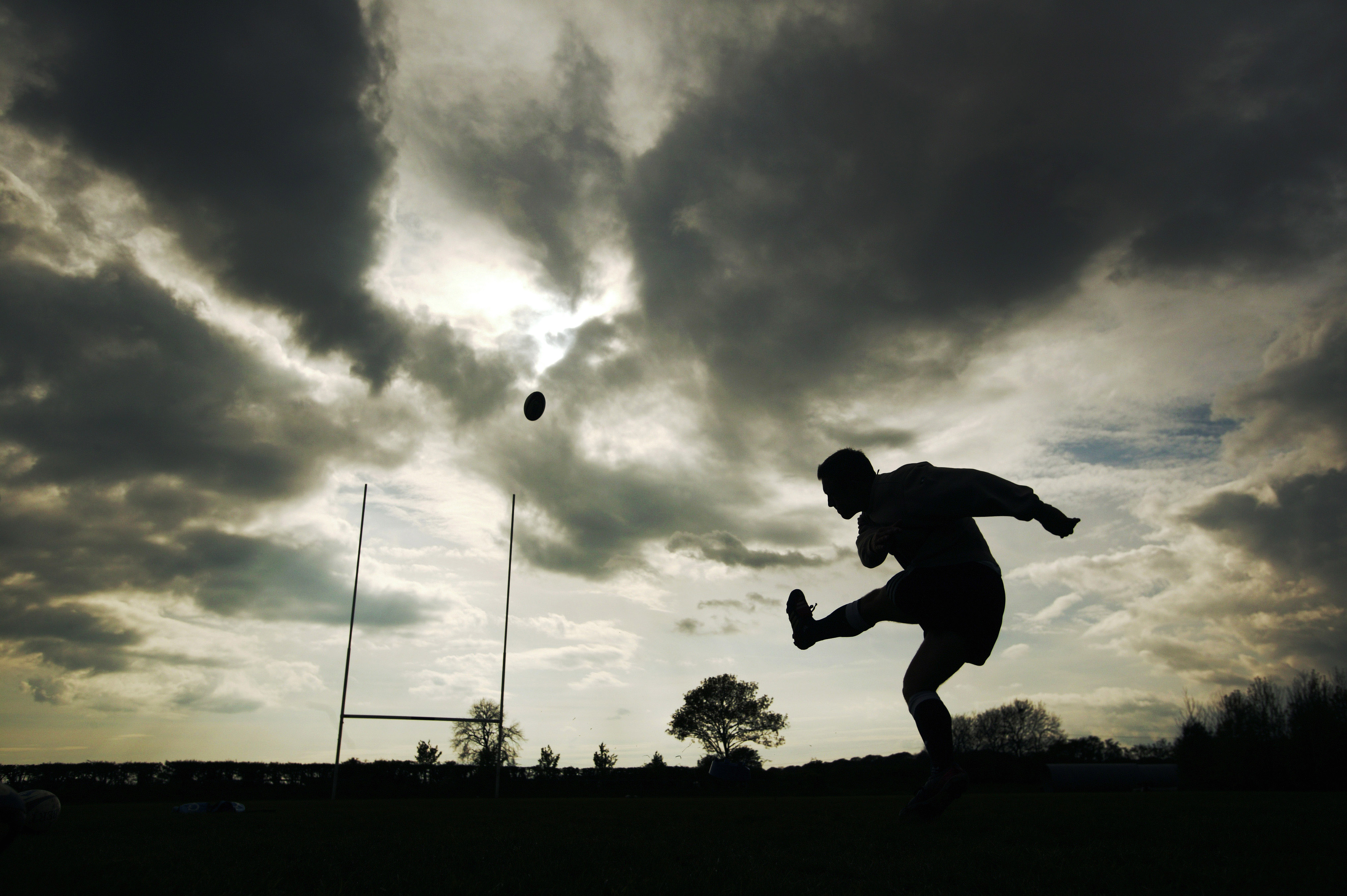 Silhouette of Jonny Wilkinson kicking a rugby ball.