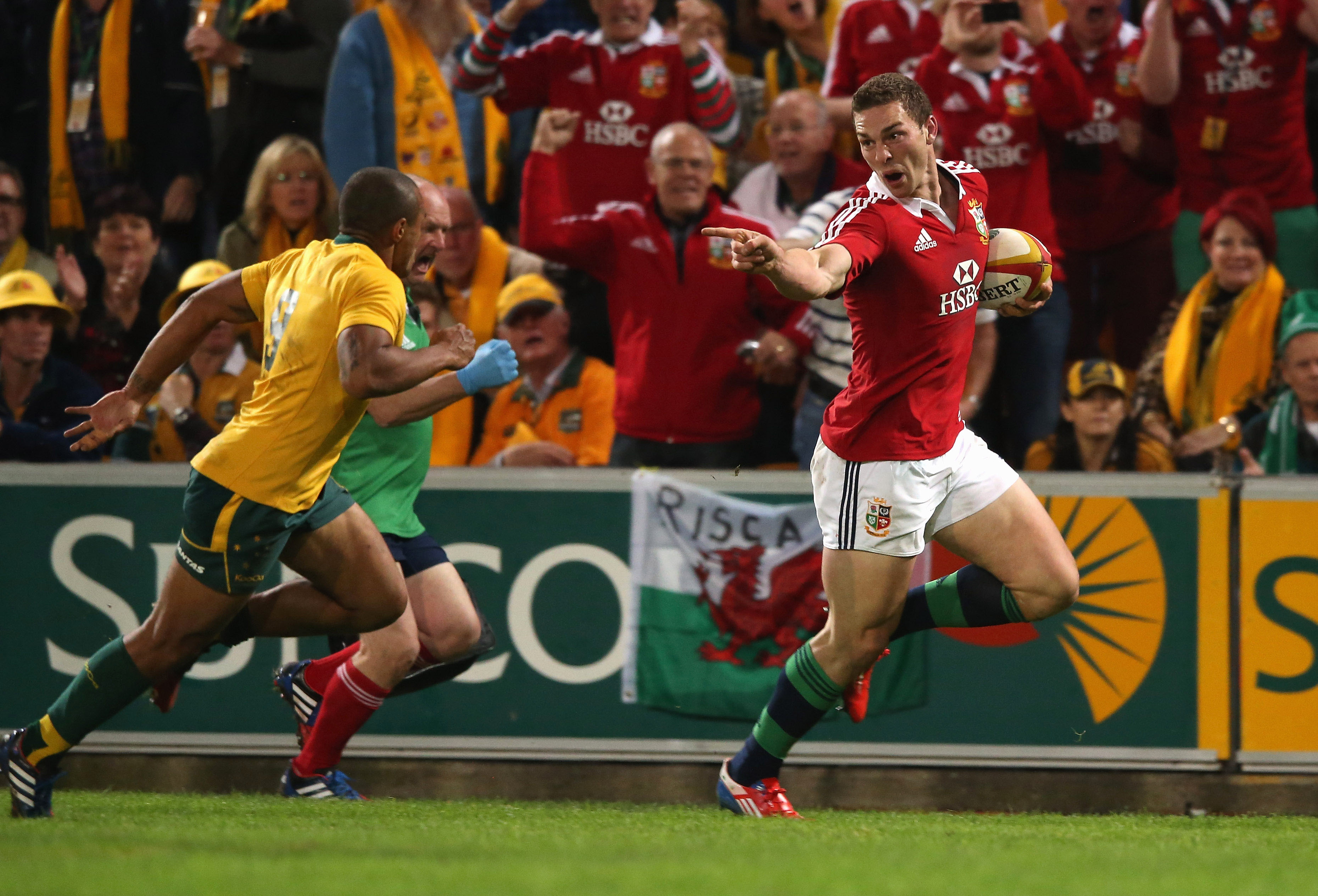 George North taunts Will Genia as he scores the first Lions try.