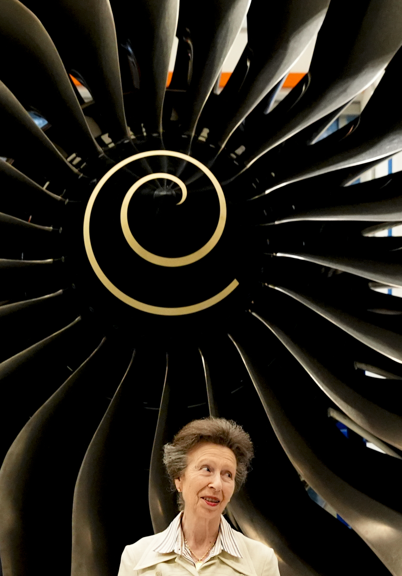The Princess Royal standing in front of a Rolls-Royce engine.