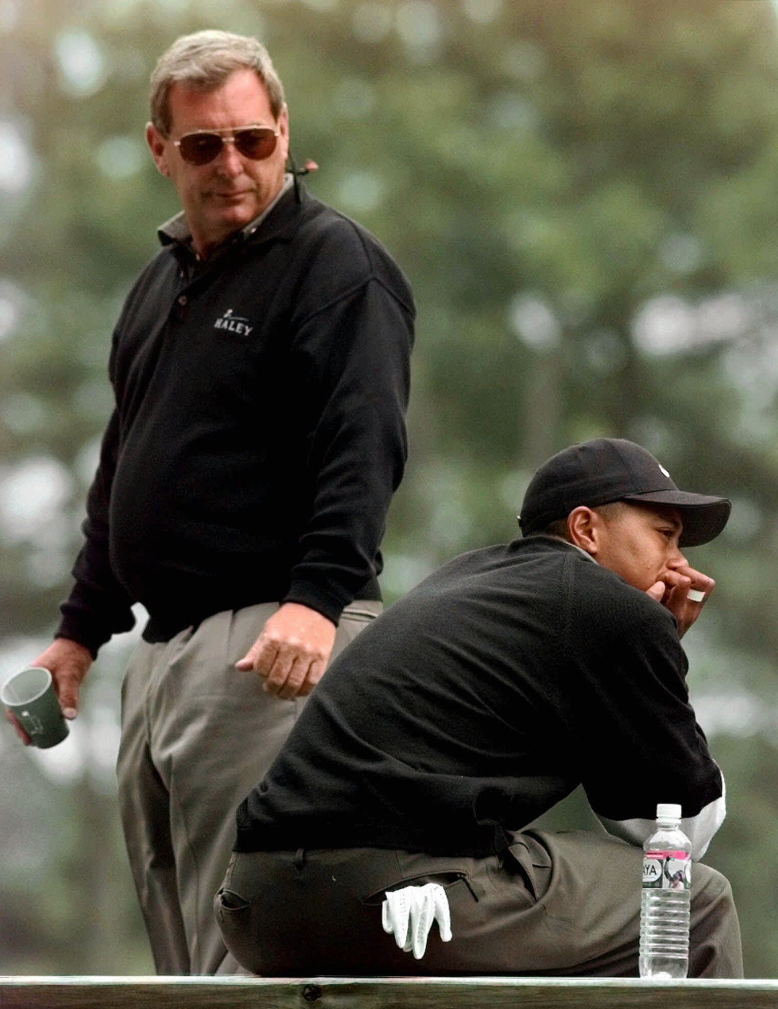 Fuzzy Zoeller looks back at Tiger Woods, who is seated and looking down, at the 1998 Masters.