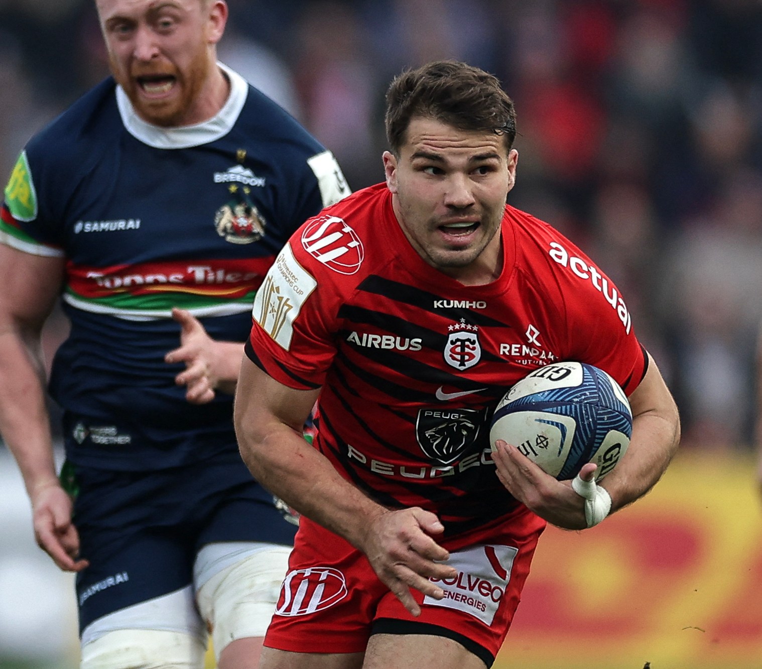 Antoine Dupont of Toulouse runs with the ball during a rugby match against Leicester Tigers.