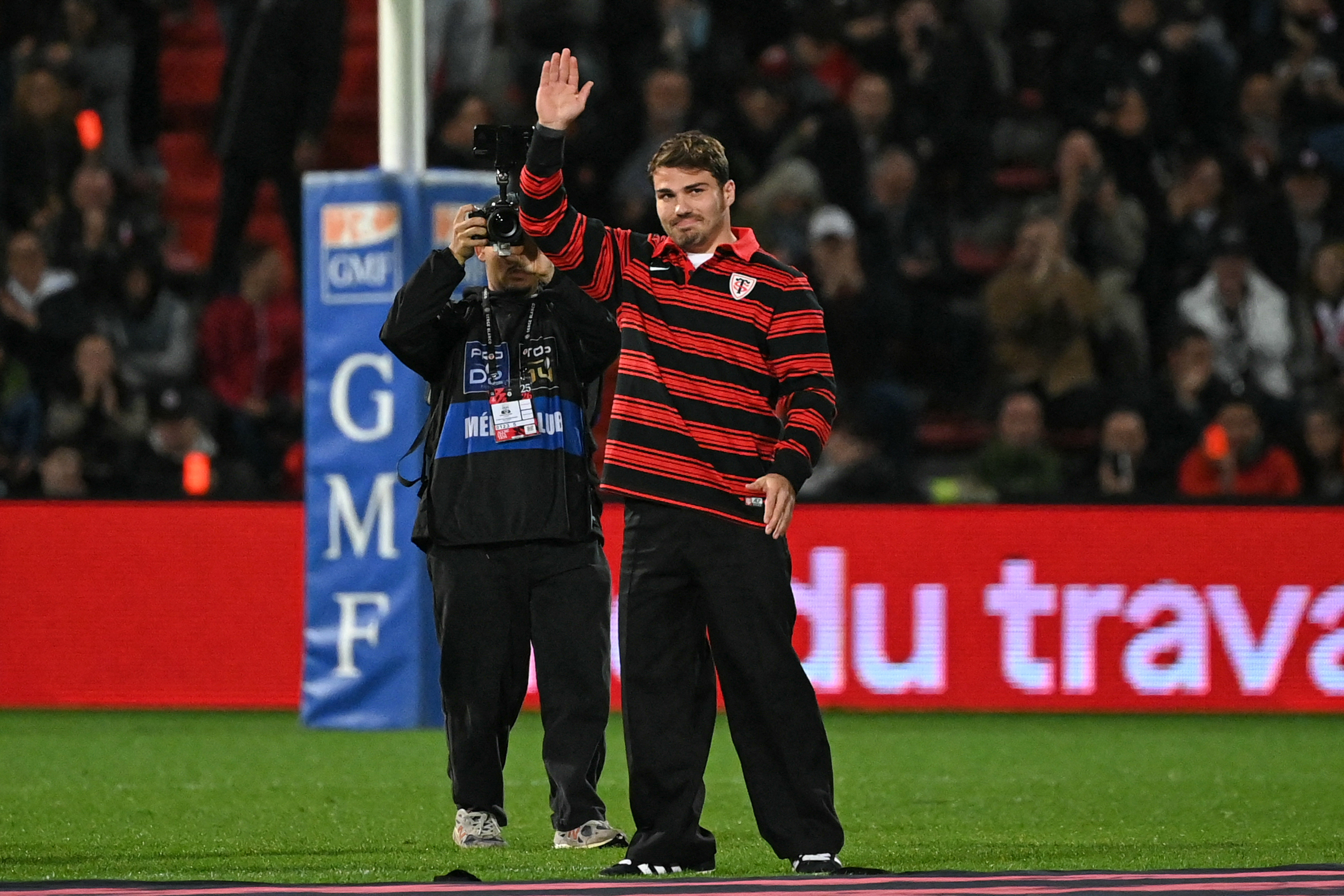 Toulouse scrum-half Antoine Dupont waves to the crowd after his contract extension.