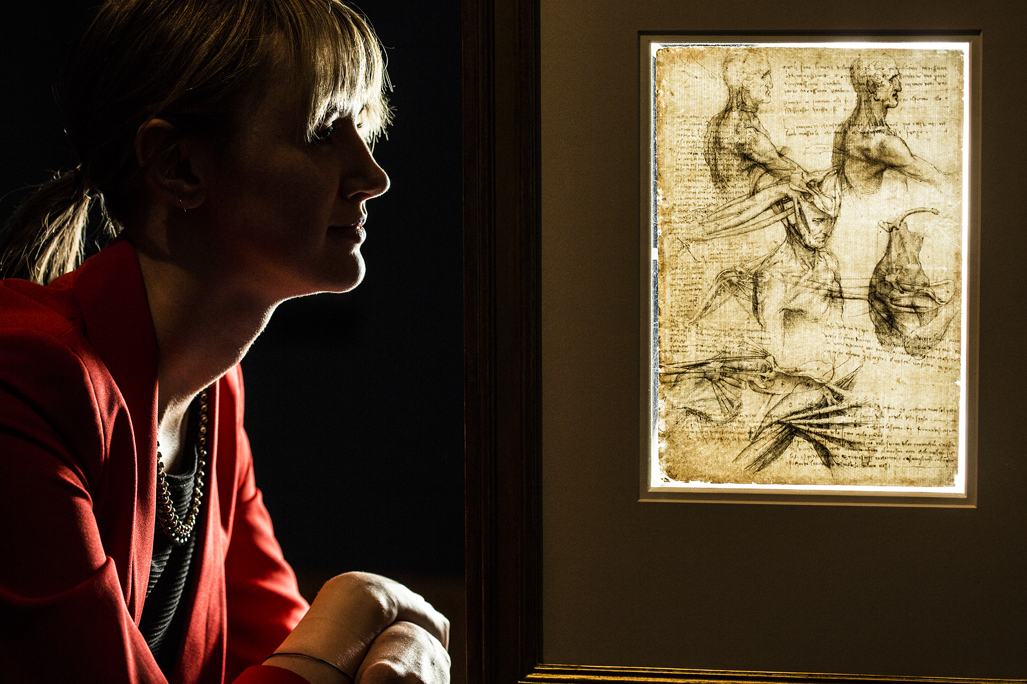 Sophie Lawrenson poses next to Leonardo da Vinci's anatomical drawing of the human body.