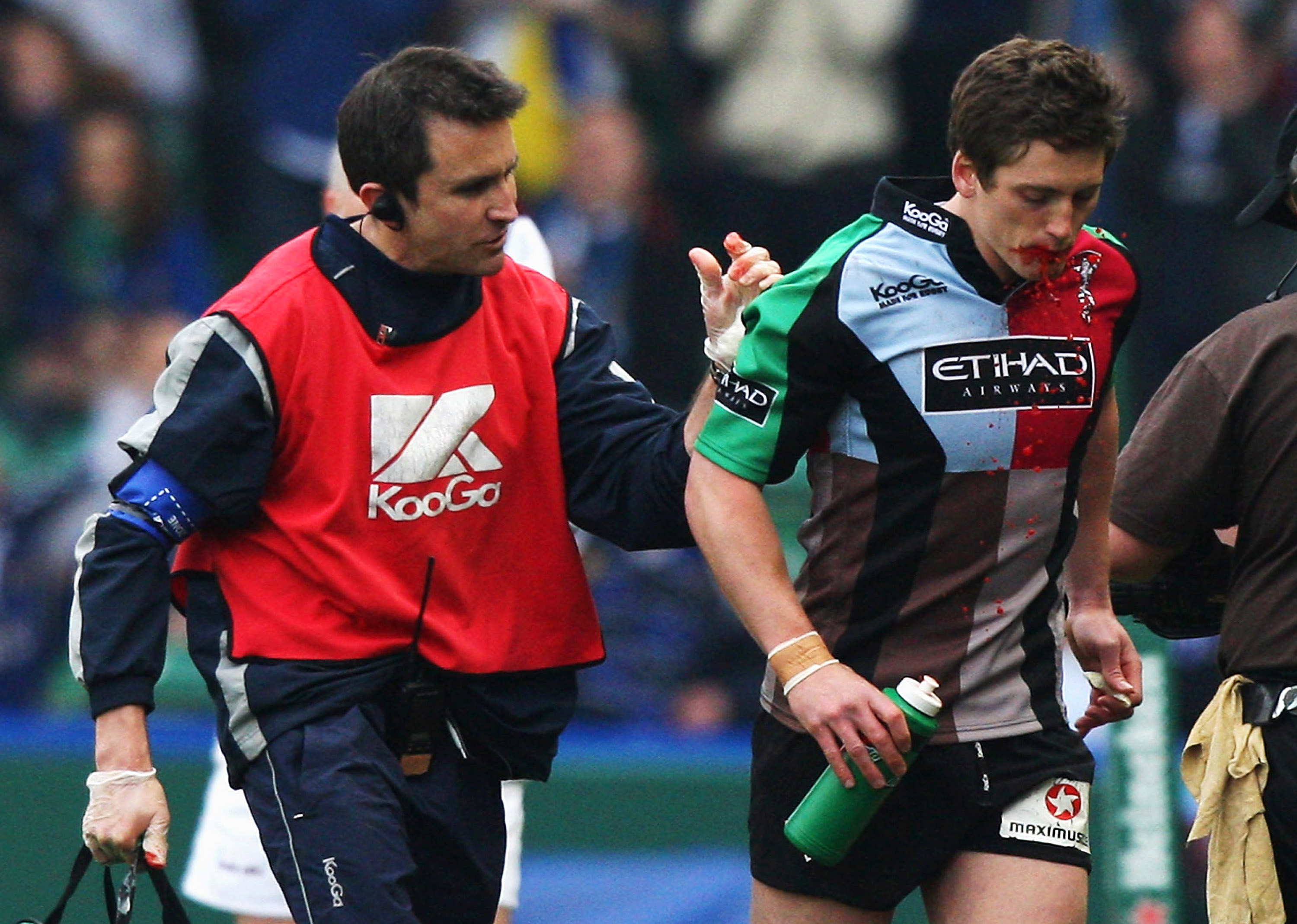 Rugby player Tom Williams walks off the field with blood spilling from his mouth.