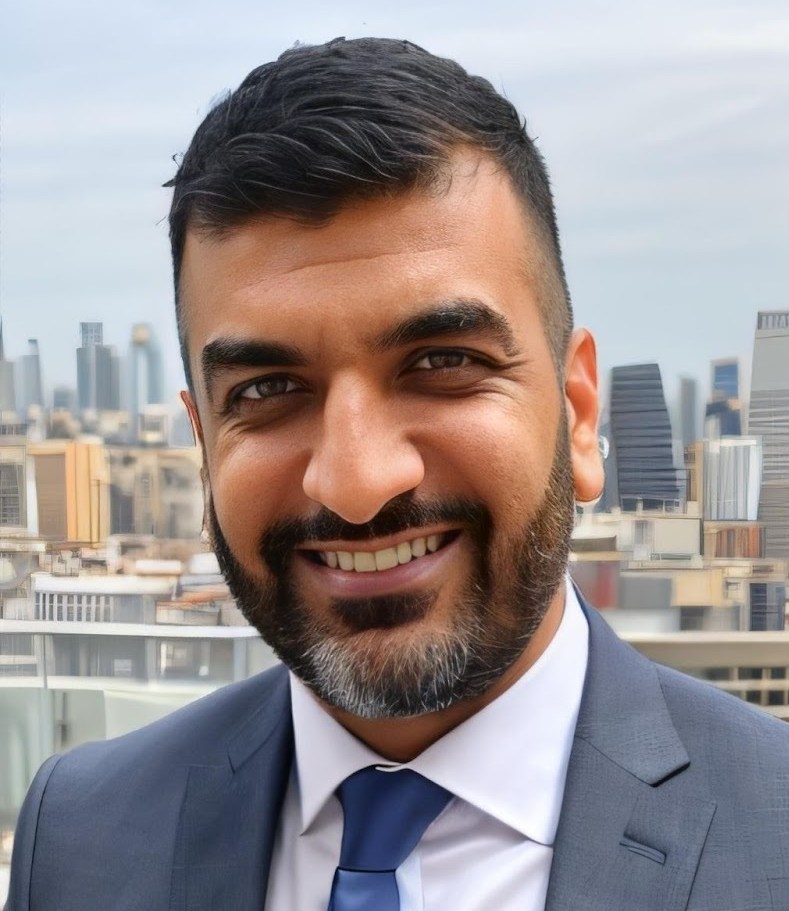 Zahid Razzaq, a smiling man in a suit and tie, with a cityscape in the background.
