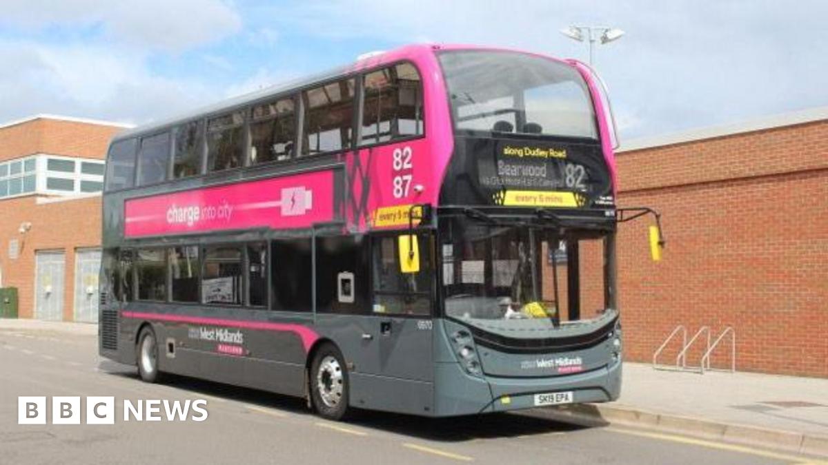 A dark grey double decker bus with a pink banner with West Midlands branding