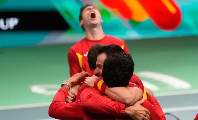 Spain's Marcel Granollers and Pedro Martinez celebrate with their teammates after winning against Germany's Kevin Krawietz and Tim Puetz during a Davis Cup double semifinal tennis match between Spain and Germany, in Bologna, Italy, Saturday, Nov. 22, 2025. (AP Photo/Luca Bruno)