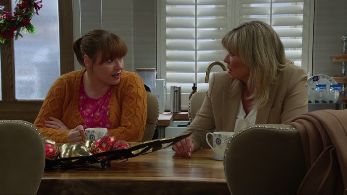 Lydia and Kim chat in Home Farm with coffee mugs in front of them in Emmerdale