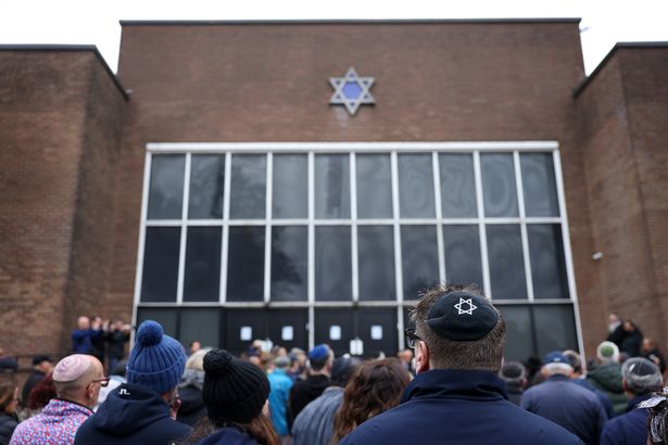 Members of the Jewish community gather outside Heaton Park synagogue