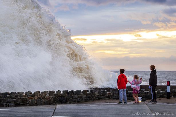 Onlookers at Barmouth promenade as giant waves crash against the resort’s seawall