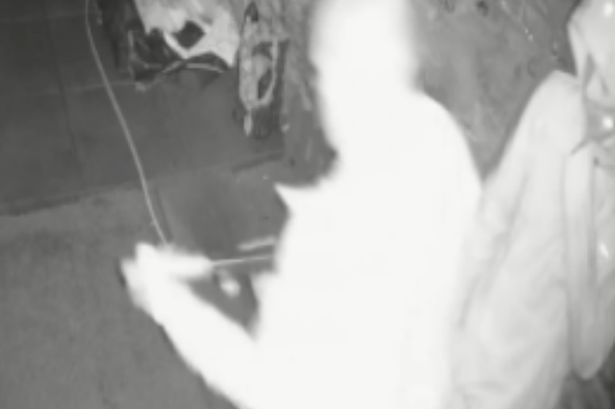 A CCTV still of Charles Byers attaching a silencer to a firearm