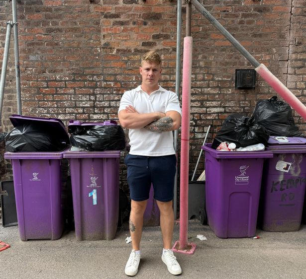 Cllr Carl Cashman in front of some bins