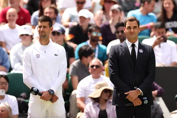 Novak Djokovic of Serbia and Roger Federer of Switzerland look on during the Centre Court Centenary Celebration on day seven of The Championships Wimbledon 2022