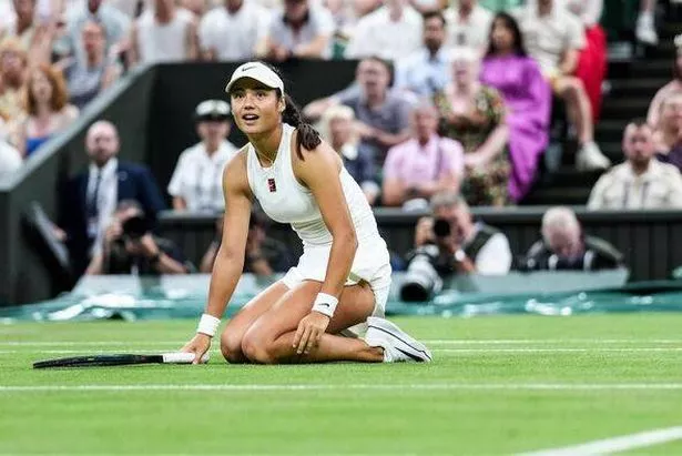 Emma Raducanu kneels on the court