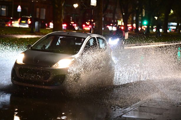 A motorist driving along the flooded Princes Road