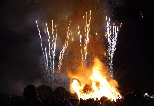 Crowd watching huge bonfire and firework display, celebrating Guy Fawkes night which is on November 5th.