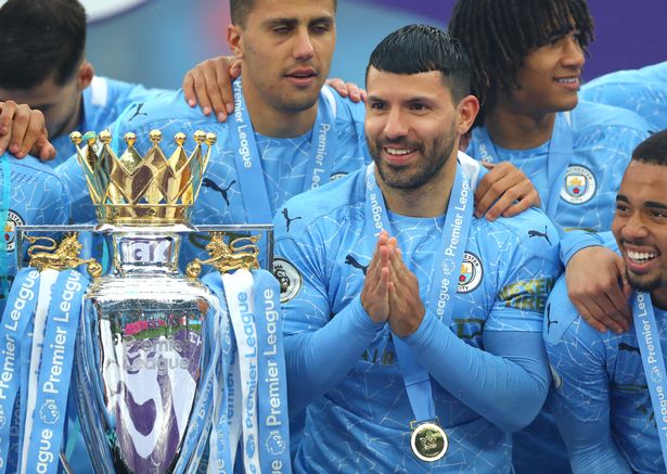 Sergio Aguero of Manchester City smiles next to the Premier League Trophy during the Premier League match between Manchester City and Everton at Etihad Stadium on May 23, 2021 in Manchester, England.