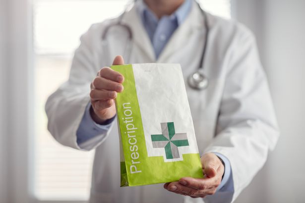 Doctor holding prescription medicine in bag at pharmacy dispensing to patient