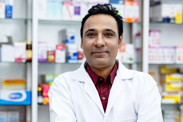 Portrait of an Indian male doctor working in at pharmacy.