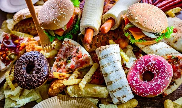 A selection of unhealthy foods including burgers, doughnuts and pizza slices