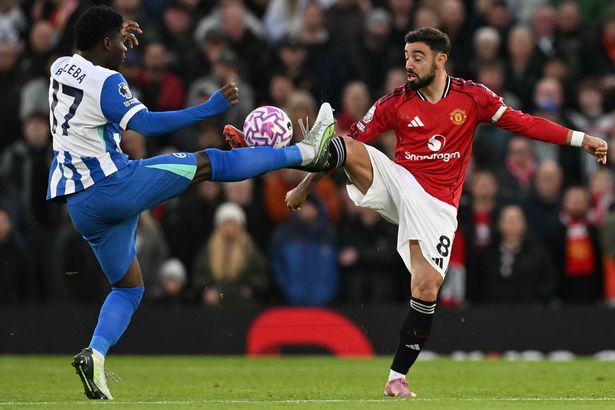 Carlos Baleba battles with Bruno Fernandes for possession during a difficult performance against Manchester United