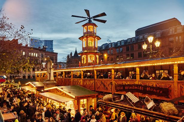 Christmas market illuminated at night, Albert Square, Manchester, UK