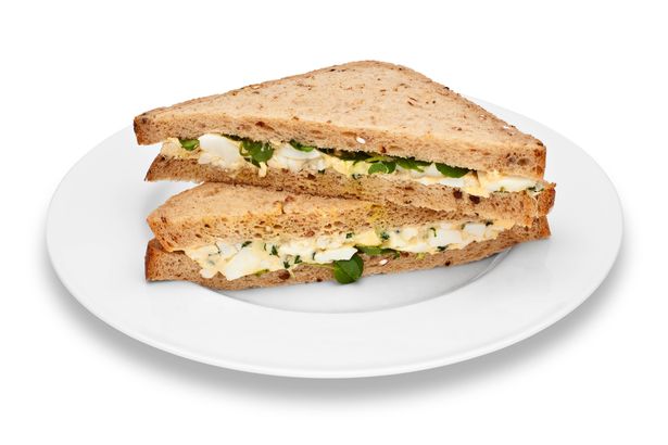 Plate of egg and watercress sandwiches, on white background, cut out