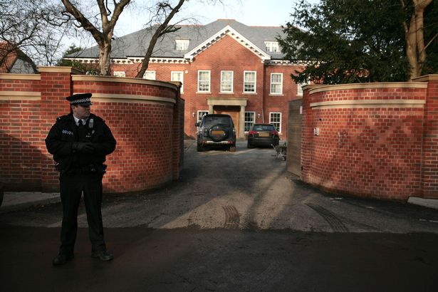 A police officer stands outside the house of Liverpool football player Steven Gerrard whose home was targeted