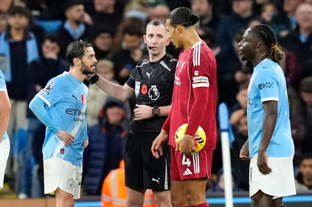 Referee Chris Kavanagh speaks to Manchester City's Bernardo Silva and Liverpool's Virgil van Dijk during a VAR check