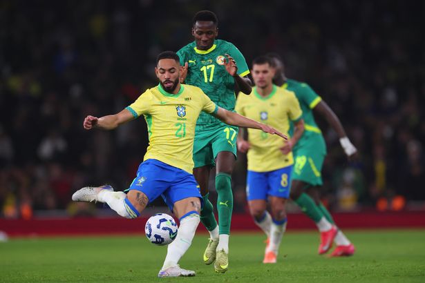 Matheus Cunha of Brazil competes for possession with Pape Matar Sarr of Senegal