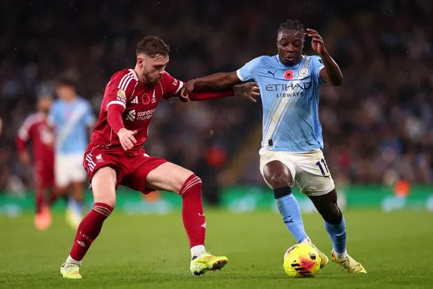 Conor Bradley of Liverpool competes for the ball with Jeremy Doku of Manchester City