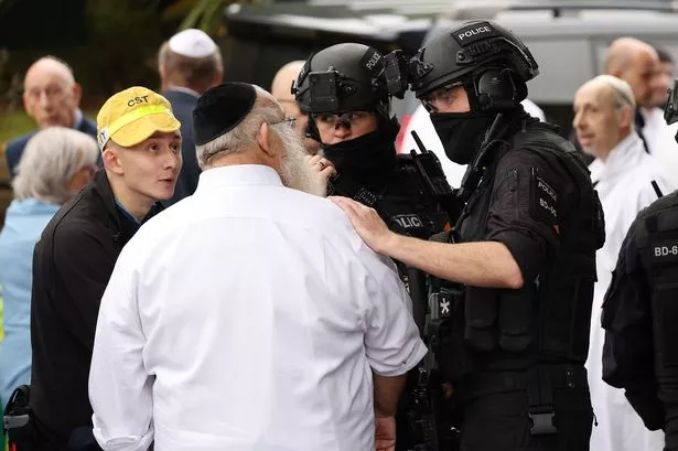 Officers speak to members of the Jewish community after the attack on Yom Kippur